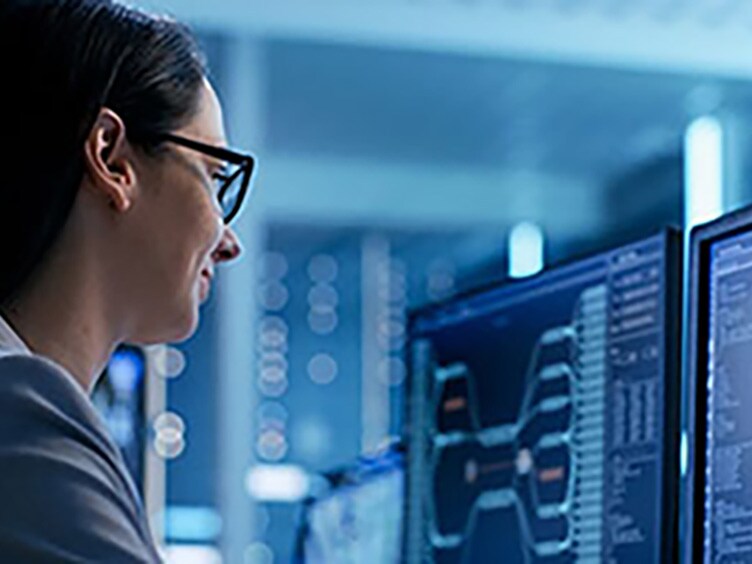 woman working in front of two computer screens