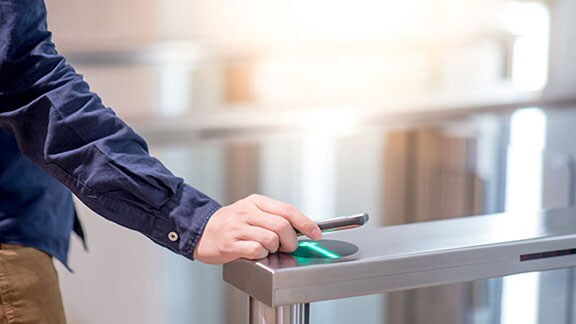 A man scanning his device in a security access device 