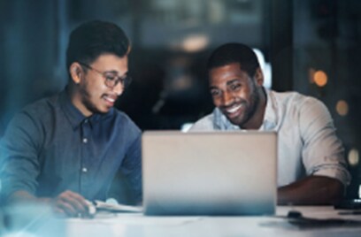 Two persons looking at the laptop and laughing