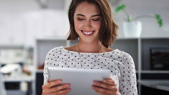 Woman smiling while using a tablet