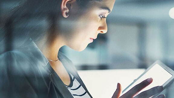 Side profile view of a woman using a tablet