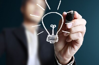 Illustration of a person sketching a glowing bulb