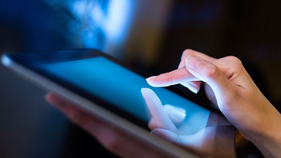 a person's finger tapping a tablet screen