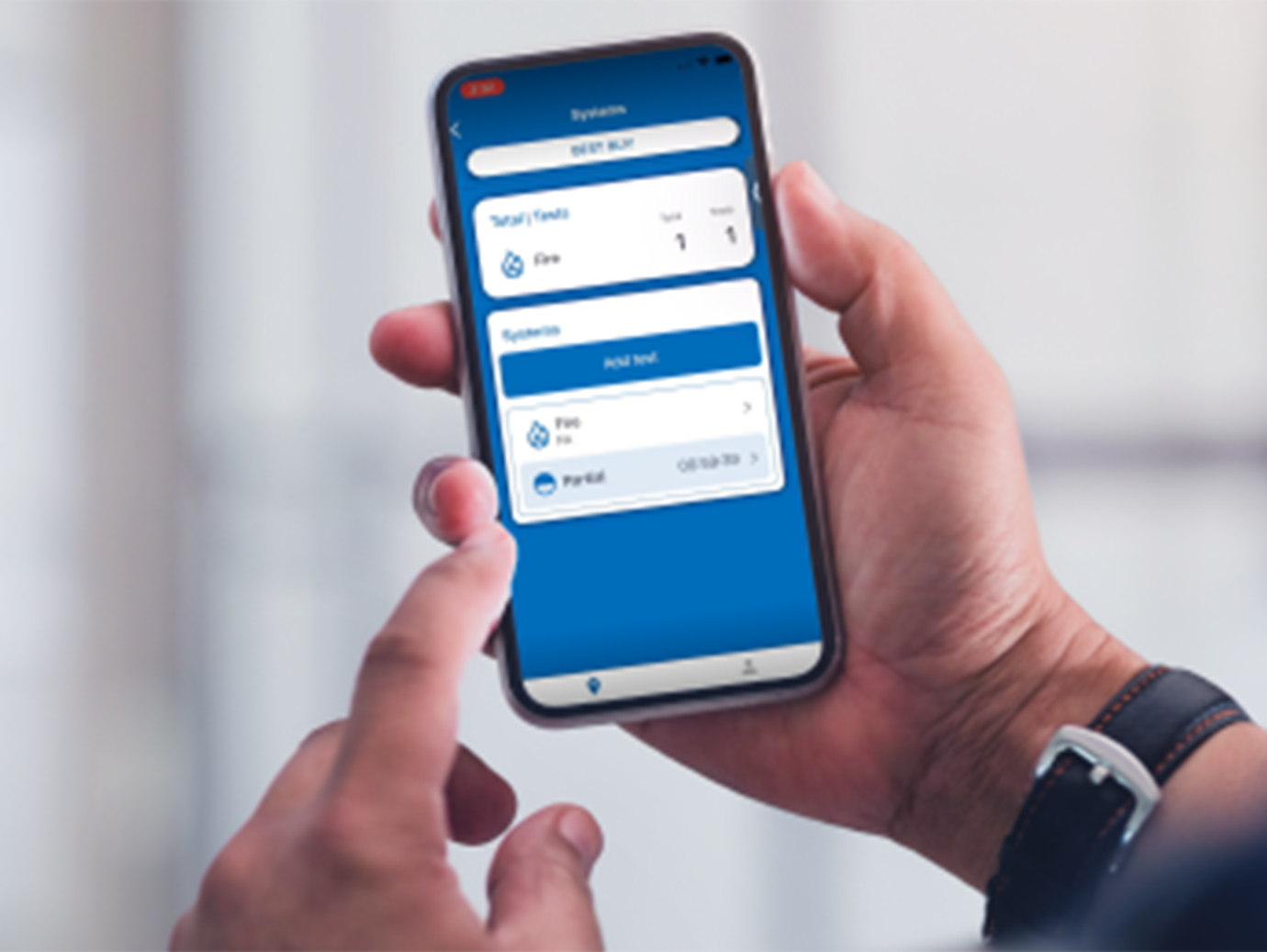 Close-up of a person holding a smartphone displaying the user interface of OpenBlue DataSource application