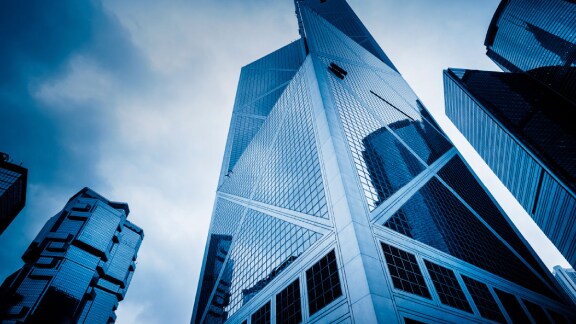 Upwards shot of a skyscraper with glass windows at dusk