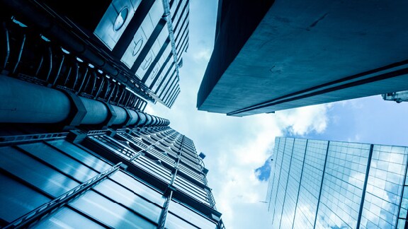 Frog's eye view of skyscrapers with clouds in the background
