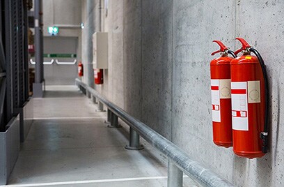Fire extinguishers on a wall in a hallway