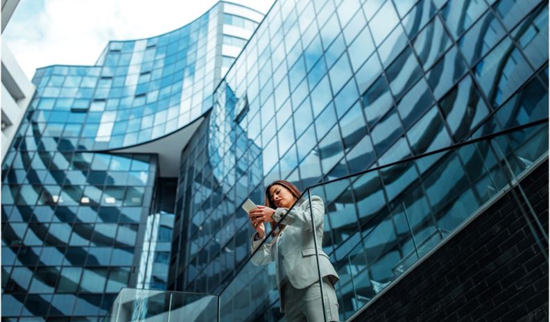 Businesswoman standing outside a modern glass office building
